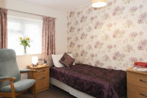 Bedroom with single bed and floral wallpaper