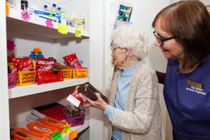 Claire helping resident to pick a pack of tissues