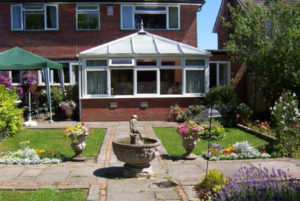 Back garden with water feature, flowers and gazebo