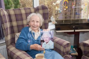 Elderly resident holds up card from The Queen