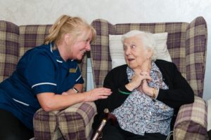 Carer sitting and talking to elderly resident