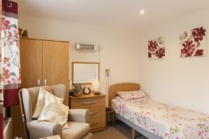 Residents bedroom in white with red floral decoration