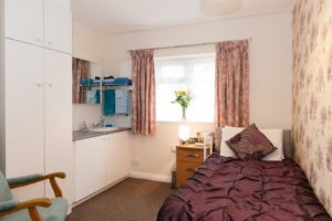 Residents bedroom with chair and washing facilities